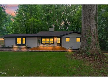 Charming home featuring a brick exterior, front porch, mature trees, and inviting curb appeal at 301 Lord Berkley Rd, Raleigh, NC 27610