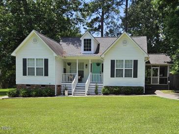 Charming one-story home with a well-manicured front yard and inviting, covered front porch at 304 Indigo Pl, Garner, NC 27529