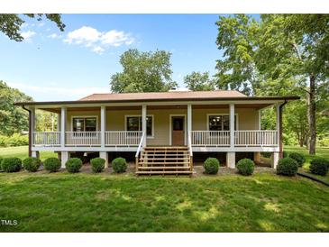Inviting front exterior with a charming porch and well-manicured lawn at 3044 Rock Springs Church Rd, Creedmoor, NC 27522