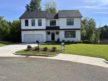Charming two-story home with a well-manicured lawn and a two-car garage at 3204 Overlook Ct, Burlington, NC 27215
