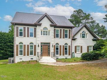 Charming two-story painted brick home with a manicured lawn and detailed trim at 3901 Phlox Rd, Raleigh, NC 27616