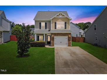 Charming two-story home with a manicured lawn, stone accents, and an attached one car garage at 504 Gumview Cir, Fuquay Varina, NC 27526