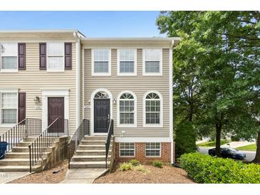 Charming townhome with a black door, arched windows, and well-maintained landscaping at 5545 Crabtree Park Ct, Raleigh, NC 27612
