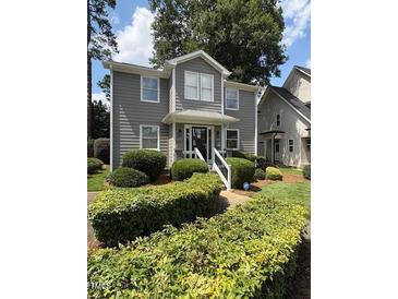 Charming two-story home featuring a well-manicured lawn and beautiful, mature landscaping at 627 New Road, Raleigh, NC 27608