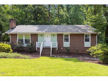 Charming brick home with well-maintained lawn and landscaped garden, offering great curb appeal at 7916 Foxwood Dr, Raleigh, NC 27615