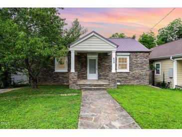 Charming stone home with a well-manicured lawn and stone walkway leading to the front door at 919 Chester St, Durham, NC 27701