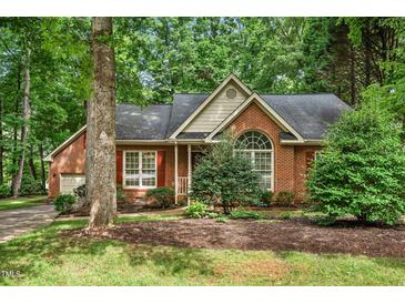 Charming brick home with manicured landscaping and mature trees, creating curb appeal at 101 Turnberry Ln, Cary, NC 27511