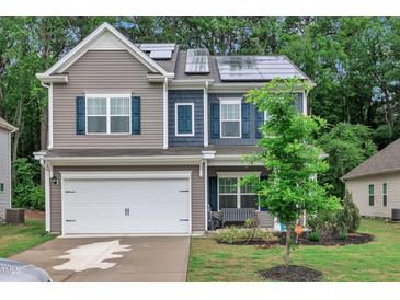 Charming two-story home with grey siding, blue shutters, well-manicured lawn and solar panels at 111 S Rose Hill Dr, Clayton, NC 27520