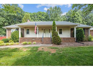 Charming ranch home featuring a covered front porch, brick accents, and a well-maintained lawn at 211 Forestview Dr, Elon, NC 27244