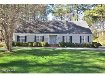 Charming home featuring a lush green lawn, mature trees, and manicured landscaping, framed by traditional shutters at 322 Gravley Dr, Rocky Mount, NC 27804