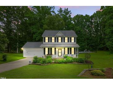 Charming two-story home with well-manicured lawn and inviting front porch perfect for relaxing at 3421 Kistler Ct, Willow Springs, NC 27592