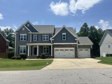 Charming two-story home with a three car garage and a beautifully landscaped front yard at 7008 Rex, Holly Springs, NC 27540