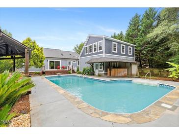 A stunning backyard oasis featuring a sparkling pool with a poolside bar, perfect for entertaining and relaxation at 7132 Deer Brook St, Willow Springs, NC 27592