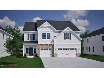 A charming two-story home with a three-car garage, landscaped yard, and a beautiful architectural design at 85 Guardian St, Youngsville, NC 27596