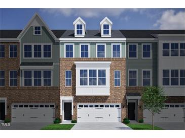 Charming townhome exterior featuring brick facade, white trim, and a two car garage at 952 Westerland Way # 142, Durham, NC 27703