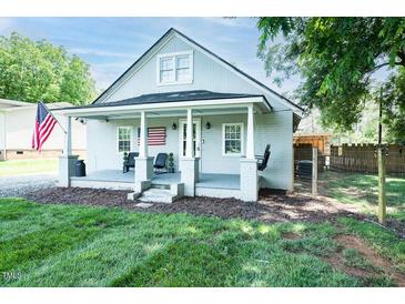 Charming bungalow with gray painted brick, covered porch, and American flag at 1146 W Holt St, Mebane, NC 27302