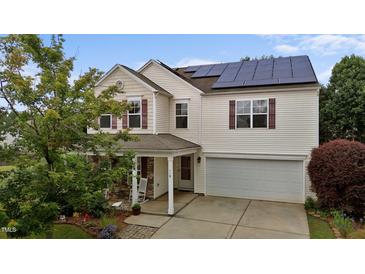 Inviting two-story home with solar panels, attached garage, and charming stone-accented front porch at 119 Tadworth Ct, Mebane, NC 27302