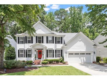 Charming two-story white home with black shutters, a red door and attached two-car garage at 2422 Castleburg Dr, Apex, NC 27523