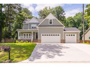 Charming two-story home with a two-car garage, landscaped yard, and lovely curb appeal at 293 Carolina Oaks Ave, Smithfield, NC 27577