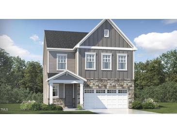 Charming two-story home with stone accents, gray siding, white trim and a two car garage at 317 Calvander Ln, Apex, NC 27539