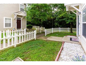 Charming home features a white picket fence and a well-manicured lawn, creating a welcoming entrance at 320 Gilman Ln # 106, Raleigh, NC 27610