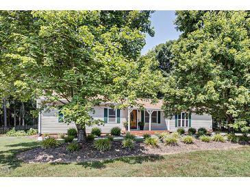 Charming single-story home with mature trees, green shutters, and landscaped front yard at 835 Pearleman Teague Rd, Siler City, NC 27344