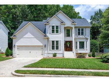 Charming two-story traditional home with a well-manicured lawn, attached garage, and welcoming front entrance at 8841 Deerland Grove Dr, Raleigh, NC 27615