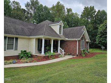 Charming home featuring a well-manicured lawn and beautifully landscaped front yard at 100 Deer Ridge Rd, Siler City, NC 27344