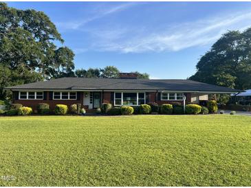 Well-maintained single-story brick home featuring a lush front yard with manicured landscaping at 12082 Nc 42, Fuquay Varina, NC 27526