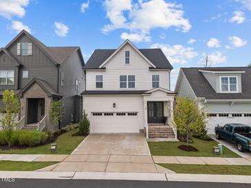 Charming two-story home with white siding, attached garage, and beautifully landscaped front yard at 140 Big Barn Dr, Wendell, NC 27591