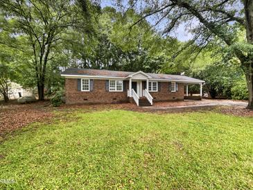 Charming brick home featuring a well-maintained lawn and surrounded by mature trees at 1508 Hodge Rd, Knightdale, NC 27545