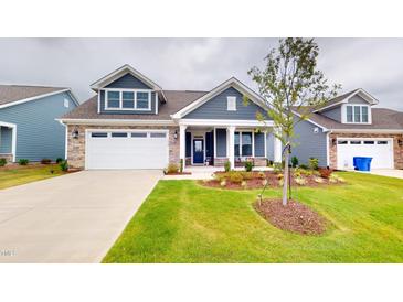 Charming home featuring a two-car garage, manicured lawn and tasteful landscaping at 1720 Pinecliff Ct, Fuquay Varina, NC 27526