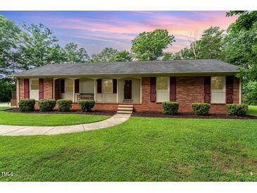 Charming single-story brick home featuring a well-manicured lawn and lovely front porch at 2139 Race Track Rd, Burlington, NC 27215
