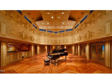 This music room is fully equipped with a grand piano, sound-engineered walls, and paneled ceiling at 2540 Seaforth Rd, Pittsboro, NC 27312