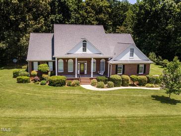Charming brick home featuring a welcoming front porch and beautifully landscaped yard at 2819 Russell Mcpherson Rd, Burlington, NC 27215