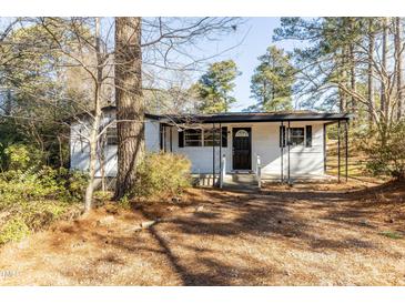 Charming single-story home with a covered porch and well-maintained landscaping, surrounded by mature trees at 3013 Avery St, Raleigh, NC 27610