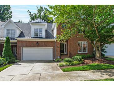 Charming brick home featuring an attached two-car garage and professionally landscaped front yard at 4211 Norman Ridge Ln, Raleigh, NC 27613