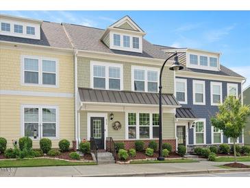 Charming townhouse featuring colorful exteriors, well-manicured landscaping, and inviting front entrances at 513 Brooks St, Wake Forest, NC 27587