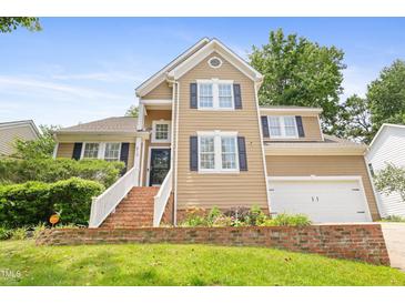 Inviting two-story home with brick-lined steps and manicured landscaping, plus a garage at 613 Penncross Dr, Raleigh, NC 27610