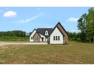 Stunning two-story home featuring white siding, stone accents, black trim and a well-manicured front yard at 7620 Sam Hall Rd, Oxford, NC 27565