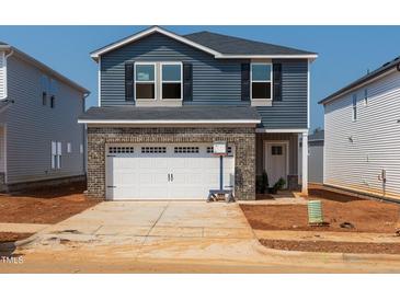 Two-story home features blue siding, a gray brick garage, black shutters, and a concrete driveway at 808 Ottawa Dr, Garner, NC 27529