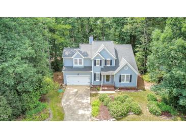 Charming two-story home featuring a lush, landscaped front yard and attached two-car garage at 107 E Seve Ct, Morrisville, NC 27560