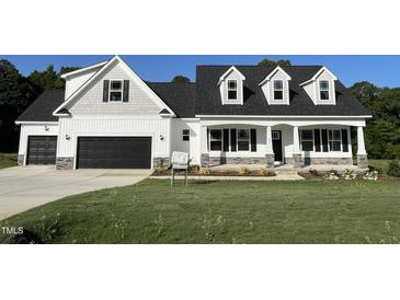 Charming new construction home showcasing a two-car garage, inviting porch, and manicured lawn at 129 Hot Springs Way, Benson, NC 27504