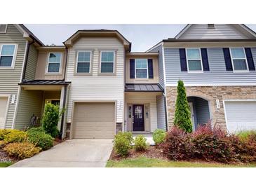 Charming townhouse with beige siding, front garden, and attached one-car garage with concrete driveway at 1365 Scholar Dr, Durham, NC 27703