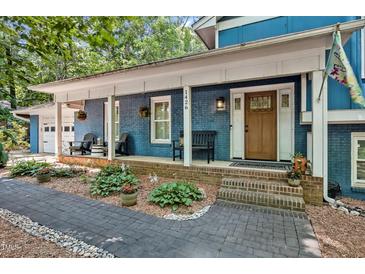 Charming brick home featuring a welcoming front porch with beautiful landscaping at 1426 Kildaire Farm Rd, Cary, NC 27511