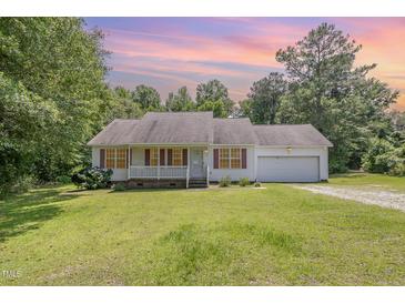 Charming single-story home with a well-manicured lawn and attached garage at 3336 Piney Grove Wilbon Rd, Fuquay Varina, NC 27526