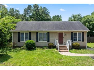 Charming one-story home featuring a well-maintained lawn, complemented by dark shutters against light siding and a brick walkway at 3624 Meadow Creek Ln, Raleigh, NC 27616
