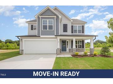 Charming two-story home with a light gray and blue exterior and a well-manicured front lawn at 44 Chloe Ct, Selma, NC 27576