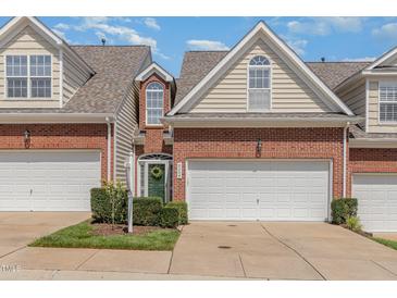 Charming brick townhome with an attached garage and a well-manicured lawn in a residential neighborhood at 8004 Thrush Ridge Ln, Raleigh, NC 27615