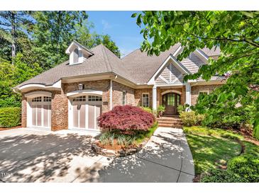 Charming brick home featuring a two-car garage, landscaped front yard, and inviting entrance at 84307 Winslow, Chapel Hill, NC 27517